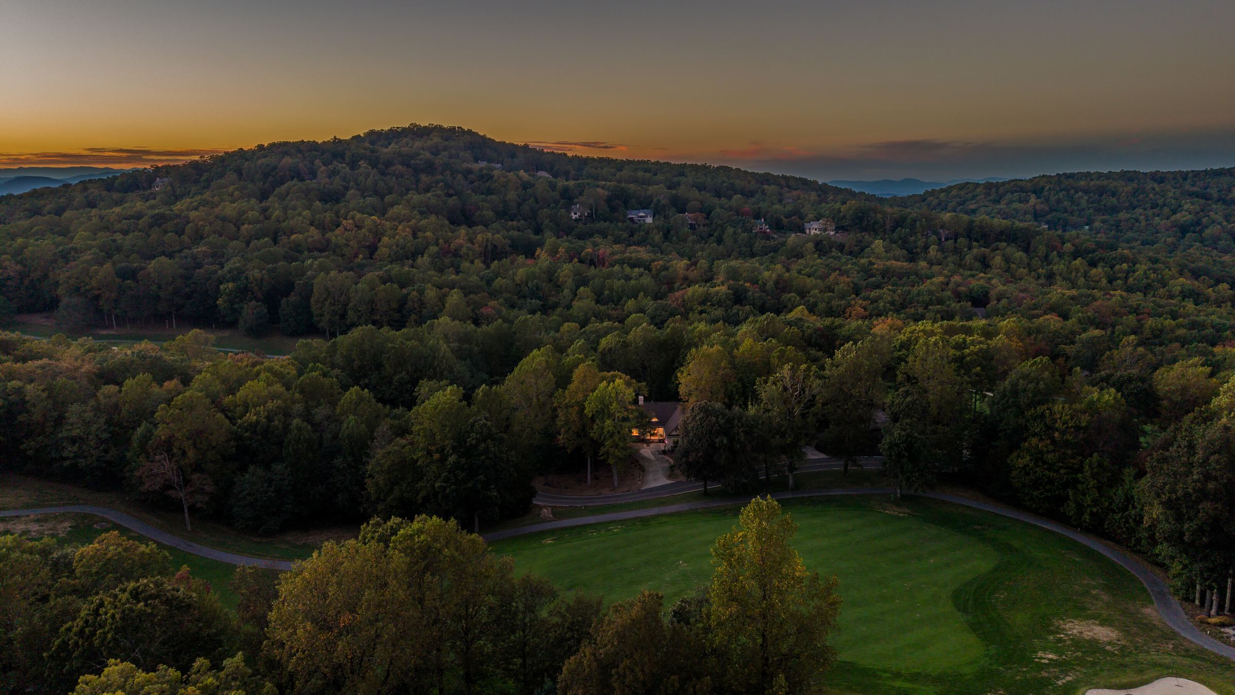 Aerial view at dusk of 1 Touch Me Not Trail in the trees above the Glassy fairway